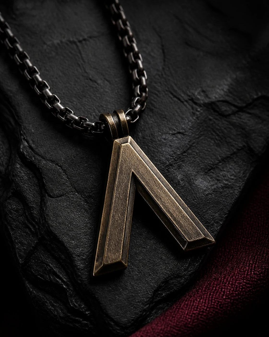 Pendentif géométrique en bronze patiné sur une pierre noire