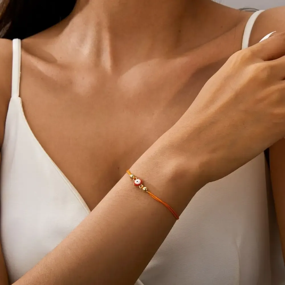 Bracelet œil grec rouge – cordon rouge et perles dorées