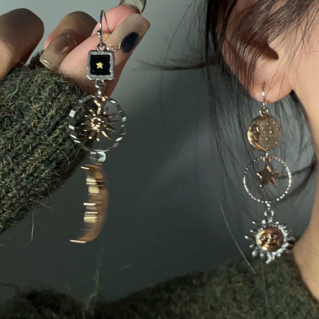 Boucles d’oreilles asymétriques soleil et lune portées à l’oreille